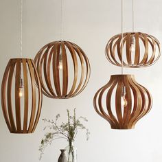 three wooden lights hanging from the ceiling above a table with plates and bowls on it