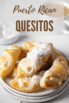 a white plate topped with powdered sugar covered pastries next to a cup of coffee