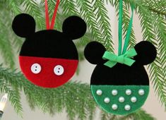 two mickey and minnie mouse ornaments hanging from a christmas tree