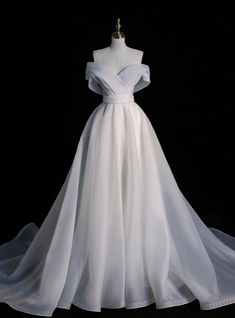 Have you dreamt of a wedding dress that will reflect the joy and purity of your special day? This pristine gown may just be the embodiment of that dream. Its off-the-shoulder elegance is highlighted by a sculptural overlay that whispers sophistication, while the cinched waist cascades into a generous A-line skirt, promising to sway ethereally with every step you take down the aisle. The fabric, a soft and sumptuous chiffon, is carefully selected to ensure comfort without sacrificing the sheer, luxurious volume that gives this dress its heart-stopping silhouette. Each seam, hidden within the folds, is meticulously sewn to create a seamless look, allowing the dress to appear as if it were crafted from one single, flawless piece of fabric. For the bride seeking a harmonious blend of tradition Prom Dresses White Long, Dresses White Long, Prom Dresses White, White Prom Dress Long, Wedding Dress Organza, Pretty Wedding Dresses, White Evening Dress, Corset Dress Prom, Long Evening Dress