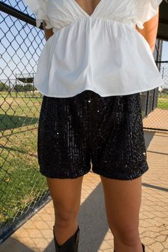 DESCRIPTION: Dazzle in our Blitz Sequin Shorts – a perfect balance of glamour and comfort. Whether you're stepping out for a night on the town or a special event, these shorts is designed to turn heads and make a statement. Pair with our matching shirt or the top of your choosing! DETAILS: Elastic waistband Satin lining Lined shorts True to size Shane is 5'10" with a 27" waist + 32B bust and is wearing a small. Carleigh is 5'2" with a 28" waist + 34B bust and is wearing a small. FABRIC: 100% Pol Glamorous Bottoms With Built-in Shorts, Party Pants With Built-in Shorts, Glamorous High-waisted Summer Shorts, Black Bottoms For Night Out With Short Legs, Black Short Leg Bottoms For Night Out, Black Short-leg Bottoms For Night Out, Summer Party Pants With Built-in Shorts, Chic Sequined Shorts For Spring, Sequined High-waisted Shorts For Night Out