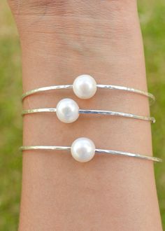 Price is for ONE bangle. Photos may show multiple bangles that are for purchase separately. Classic, chic, white freshwater pearls are always popular! These pearls are smaller than the Edison and Tahitian pearl bangles. Pearls are near round and approximately 9.5-10mm in size. They are not completely flawless and may have small dimples or surface imperfections but overall they look spectacular on a bangle! Wire is 12 gauge and available in your choice of silver or gold filled wire. These are han Handmade Bracelets For Bridesmaid Gift, Stackable Pearl Bangle Bracelet Gift, Stackable Bangle Pearl Bracelet Gift, Gift Stackable Bangle Pearl Bracelet, Adjustable Stackable Pearl Bracelet For Wedding, White Sterling Silver Bracelets For Bridesmaids, Silver Bangle Bracelets For Bridesmaid Gift, White Sterling Silver Bracelet For Bridesmaid Gift, Adjustable Bangle For Bridesmaid Gift