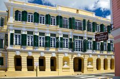 an old yellow building with green shutters