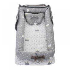 a grey and white baby bassinet with a cat design on the front, sitting in