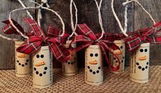 four christmas crackers wrapped in twine and tied with red plaid bows, sitting on a burlap surface