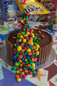 a chocolate cake with m & m candies on it and a yellow bag in the background