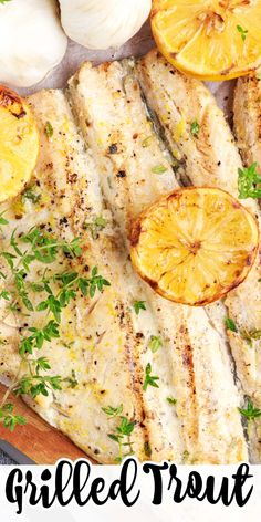 grilled fish with lemons and garlic on a cutting board