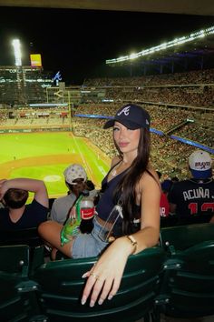 a woman sitting in the stands at a baseball game