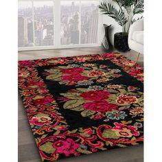 a black rug with colorful flowers on it in front of a large window and cityscape