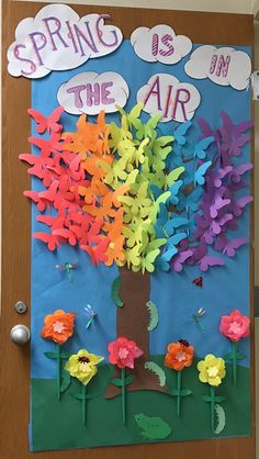 a door decorated with paper flowers and the words spring is in the air