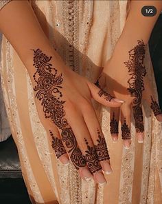 a woman's hands with henna tattoos on them