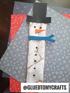 a snowman made out of paper on top of a piece of cardboard with the words glue