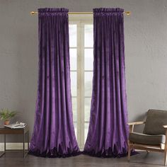 a living room with purple curtains and a chair