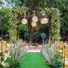 an outdoor ceremony setup with white flowers and greenery on the grass, surrounded by yellow chairs