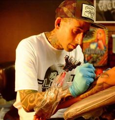 a man getting his arm tattoo done by someone