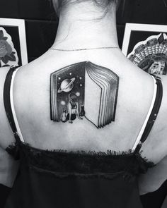 a woman with a book tattoo on her back