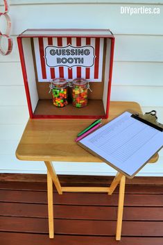 a wooden table topped with a clipboard and a box filled with gummy bears