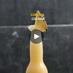 a bottle of corona beer with a piece of pineapple in it's mouth