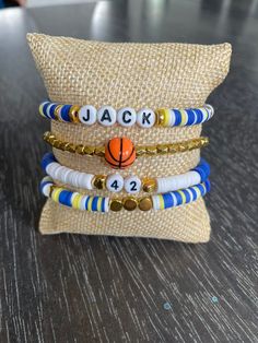 three bracelets are stacked on top of each other, with a basketball ball in the middle