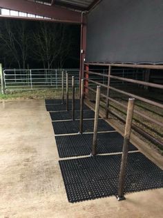 the inside of an animal pen with metal bars on each side and grass in the middle