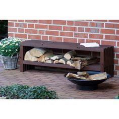 a firewood rack sitting on top of a brick patio next to a potted plant