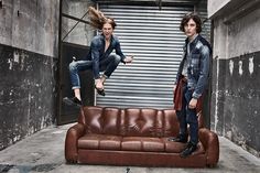 two women jumping in the air over a couch