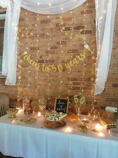 a table topped with lots of cake and dessert covered in confetti next to a brick wall