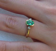 Hand made Emerald and diamond ring.  An oval Emerald is bezel set with two side diamonds also bezel set. The Emerald measures  7x5mm and the diamonds are 6 points. Ring is made in 9 carat yellow gold. Ring size is N (Australian size) or 6 1/2 (US size). Ring is ready to ship in 1-2 working days.  We resize free of charge.  Please allow a couple of additional days for resizing. Oval Emerald Diamond Ring With Bezel Setting, Classic Green Diamond Ring With Bezel Setting, Diamond Emerald Ring With Bezel Setting For Promise, Diamond Emerald Ring With Bezel Setting, Emerald Diamond Ring With Round Cut Bezel Setting, Fine Jewelry Emerald Ring With Diamond Bezel, Fine Jewelry Emerald Ring With Diamond Bezel Setting, Diamond Jewlery, Emerald Engagement Ring Green