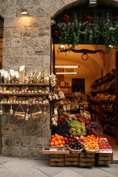 an open market with fruits and vegetables on display in front of a stone building that says, i buen y relajjaaddo sabado