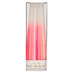 six pink and white candles in a clear box