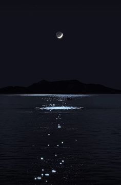 the moon shines brightly in the night sky over water with small bubbles floating on it