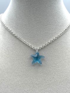 From Our By The Sea Collection :   Beautiful blue and silver come together in this dainty Swarovski crystal pendant necklace. A delightful blue starfish hangs from a sparkly silver plated brass chain. This clear blue glass pendant is small and dainty 3/4 inch wide by 3/4 inch in length. The silver chain is 16-3/4 inches long with a 1-1/2 inch chain extension and a lobster claw clasp. A pretty pendant on a shiny chain makes this necklace a lovely clothing accessory. A fun summer themed item of je Ocean Aesthetic Accessories, Blue Accessories Aesthetic, Blue Star Charm Necklace As A Gift, Blue Star Charm Necklace As Gift, Blue Jewelry With Star Charm For Jewelry Making, Blue Necklace With Star Charm As A Gift, Blue Star Charm Necklace For Gift, Ocean-inspired Star Necklaces For Gifts, Silver Crystal Necklace With Star Charm