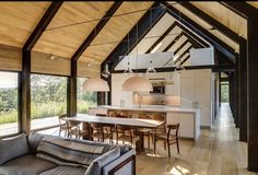 a living room filled with furniture next to a kitchen and an open concept dining area