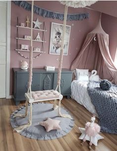 a bedroom with pink walls and wooden flooring is decorated in pastel colors, including white