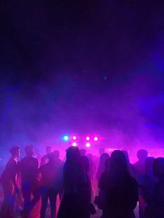 a group of people standing in front of purple and blue lights