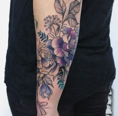 a woman's arm with flowers and leaves on it