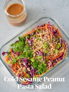 a salad in a glass dish next to a container with dressing on it and the words cold sesame peanut pasta