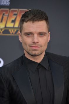 a man in a suit and tie posing for a photo at the avengers 2 world premiere