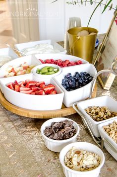 a table topped with bowls filled with fruit and nuts