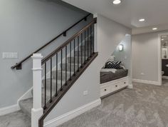 an empty living room with stairs leading up to the second floor and another bedroom in the background