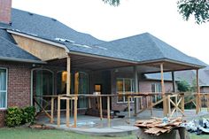 a house that is being constructed with wood and shingles on the front porch area