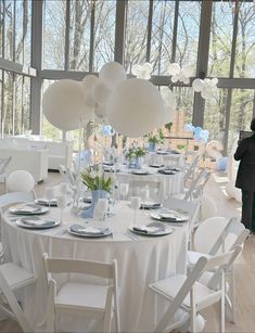 the table is set with white linens and place settings for guests to sit at