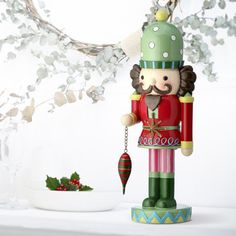 a wooden nutcracker ornament with a christmas decoration on it's head