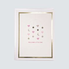 a white card with pink hearts and stars hanging from it's sides, on a light blue background