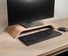 a computer monitor sitting on top of a wooden desk next to a keyboard and mouse