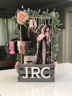 a wooden sign with clothes hanging from it's sides and the initials jrc