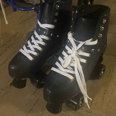 two black roller skates with white laces on them