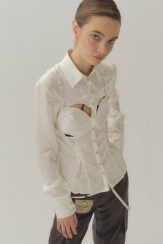 Silk tailored shirt. Fitted at waist. Breast panel adjustable. Chain button closure at front. Steamed recommended before worn. Model is 178cm (5'10), Wearing Size S. Body Color - White Button Color - Gold Body Fabric - 100% Silk Elegant Fitted Blouse With Snap Buttons, Chic Fitted Shirt With Buttons, Fitted Button-up Tops With Covered Buttons, Designer Fitted Shirt With Covered Buttons, Designer Fitted Button-up Shirt, Designer Fitted Shirt For Daywear, Chic Fitted Shirt With Covered Buttons, Fitted Shirt With Buttons For Daywear, Fitted Office Blouse With Snap Buttons