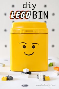 a yellow lego lunch box sitting on top of a table with lots of small legos around it