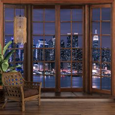 a living room with large windows overlooking the city at night